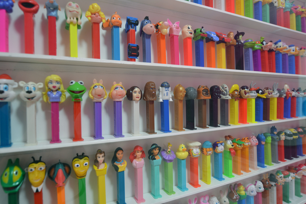 A wall of collectible candy dispensers lined up on shelves